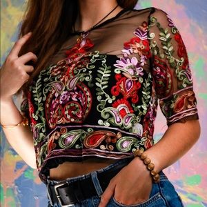 Sheer short black top with sewn colorful patterns.